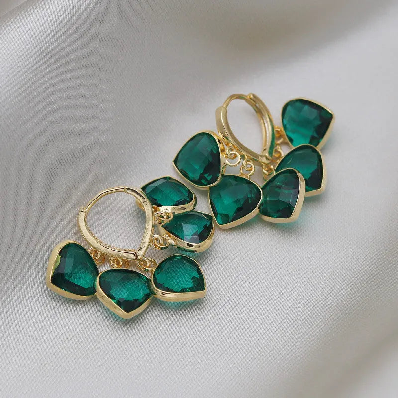Green glass heart-shaped pendant on copper ear clip earrings with alloy inlay detail.