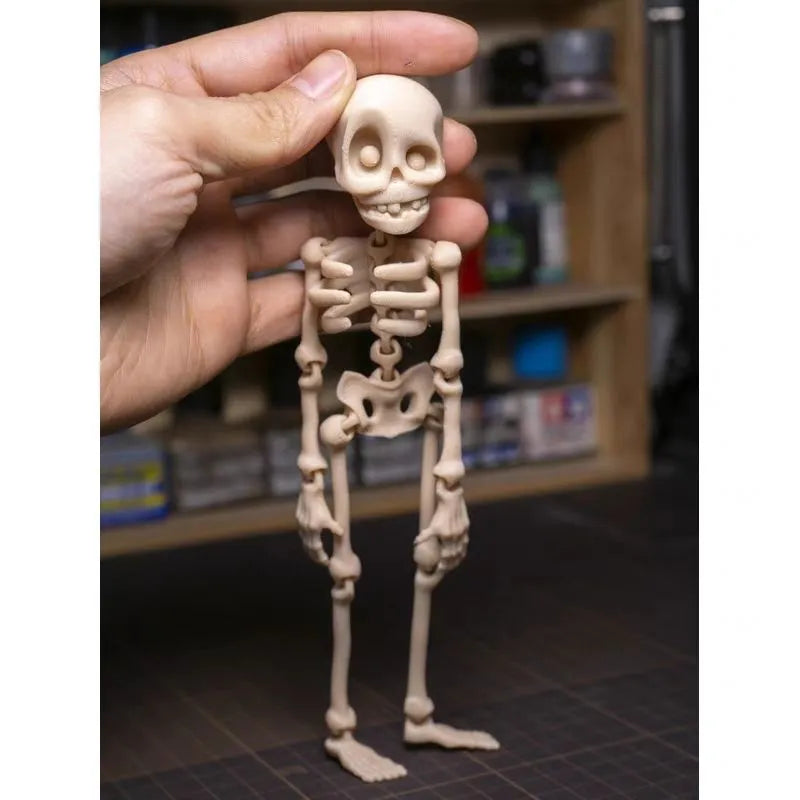 3D-printed white skull Halloween fridge magnet ornament on a refrigerator door.