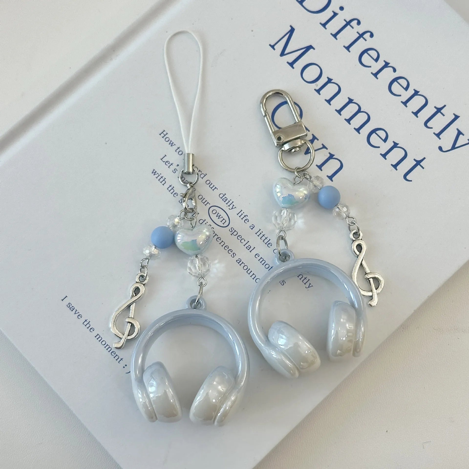 Creative music headset keychain with gradient blue resin earphone pendant and alloy keyring on a plain background