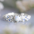 White alloy women's heart ring with floral opal ocean design, shown in multiple available sizes
