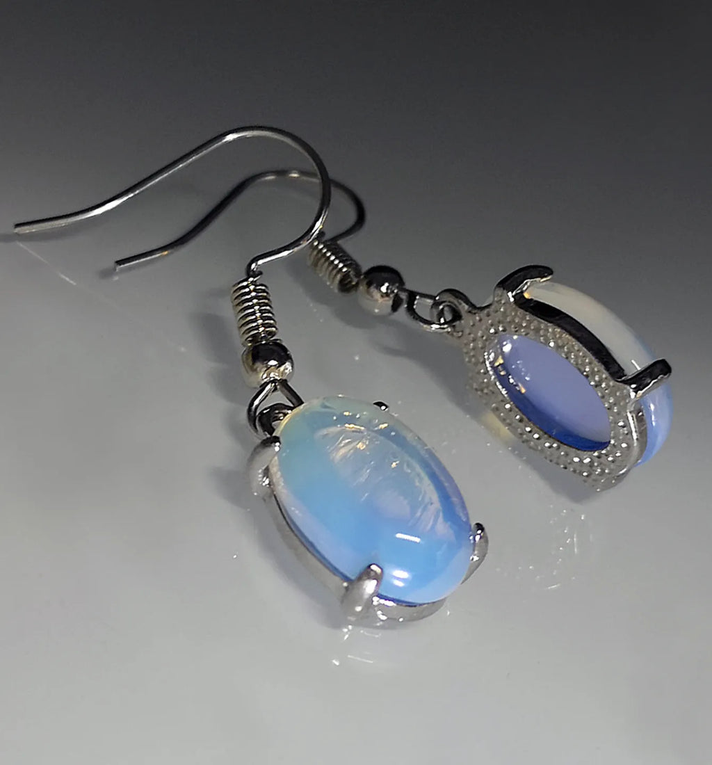 Pair of white retro-style drop earrings with a cross design and opal-like finish.