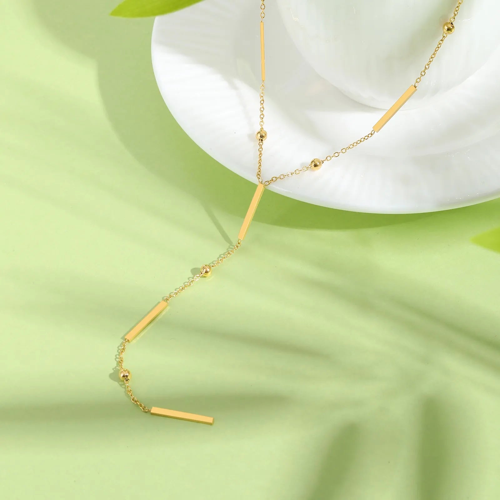Women's stainless steel gold electroplated geometric pendant necklace on display