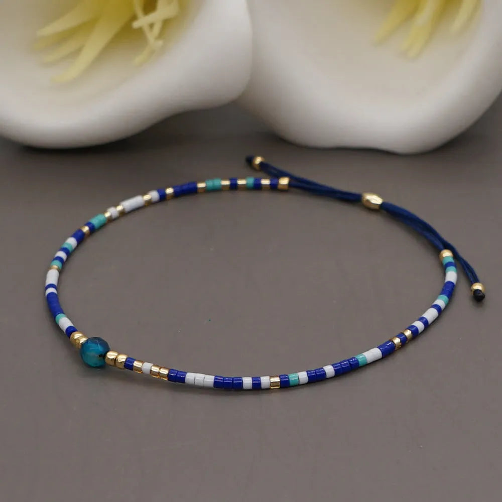 Close-up of a handmade Bohemian women's bracelet with colourful semi-precious stone and glass beads on a geometric string.