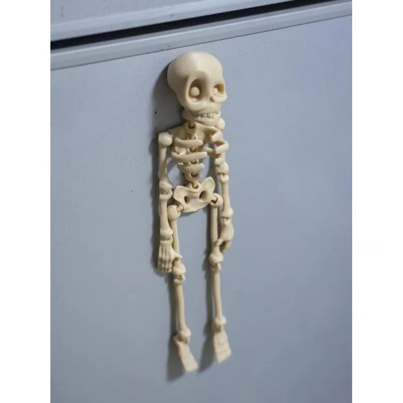 3D-printed white skull Halloween fridge magnet ornament on a refrigerator door.