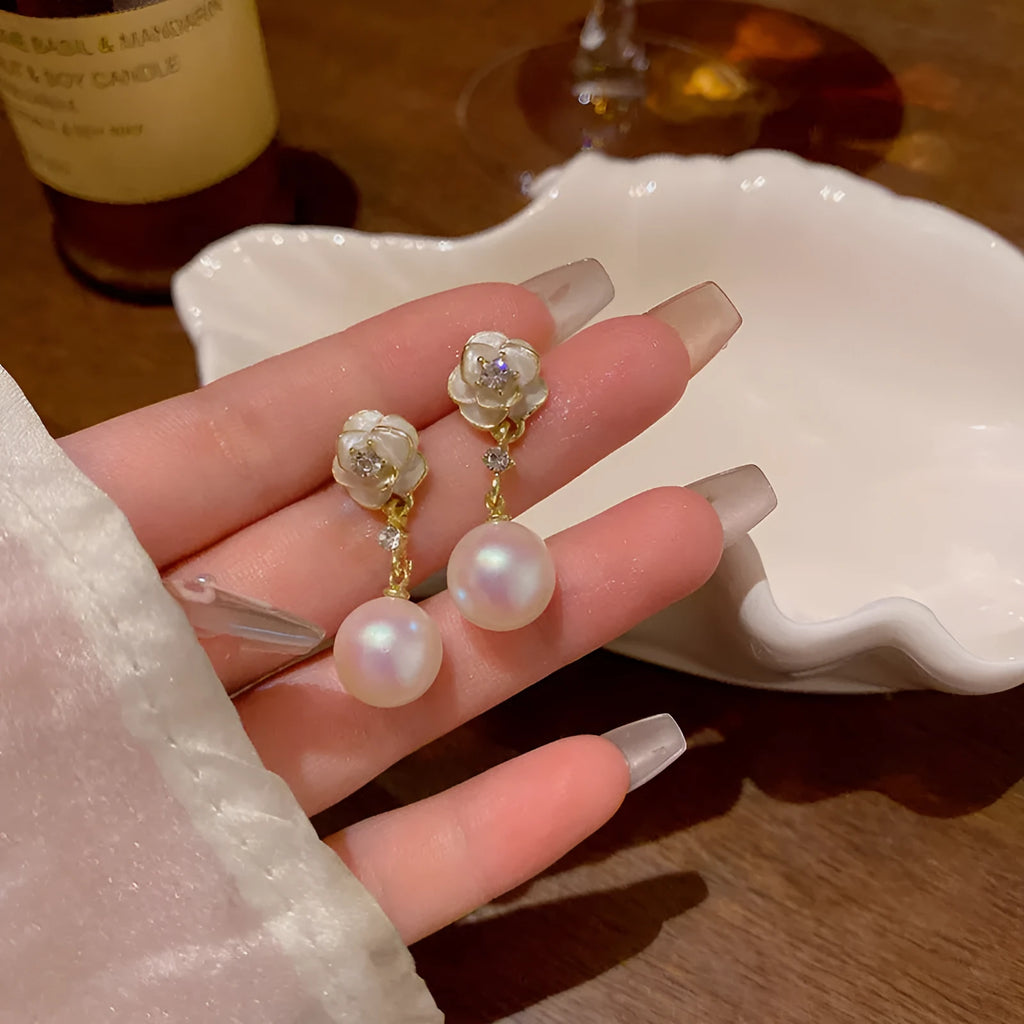 Close-up of women's camellia pearl flower stud earrings in alloy with butterfly clasp