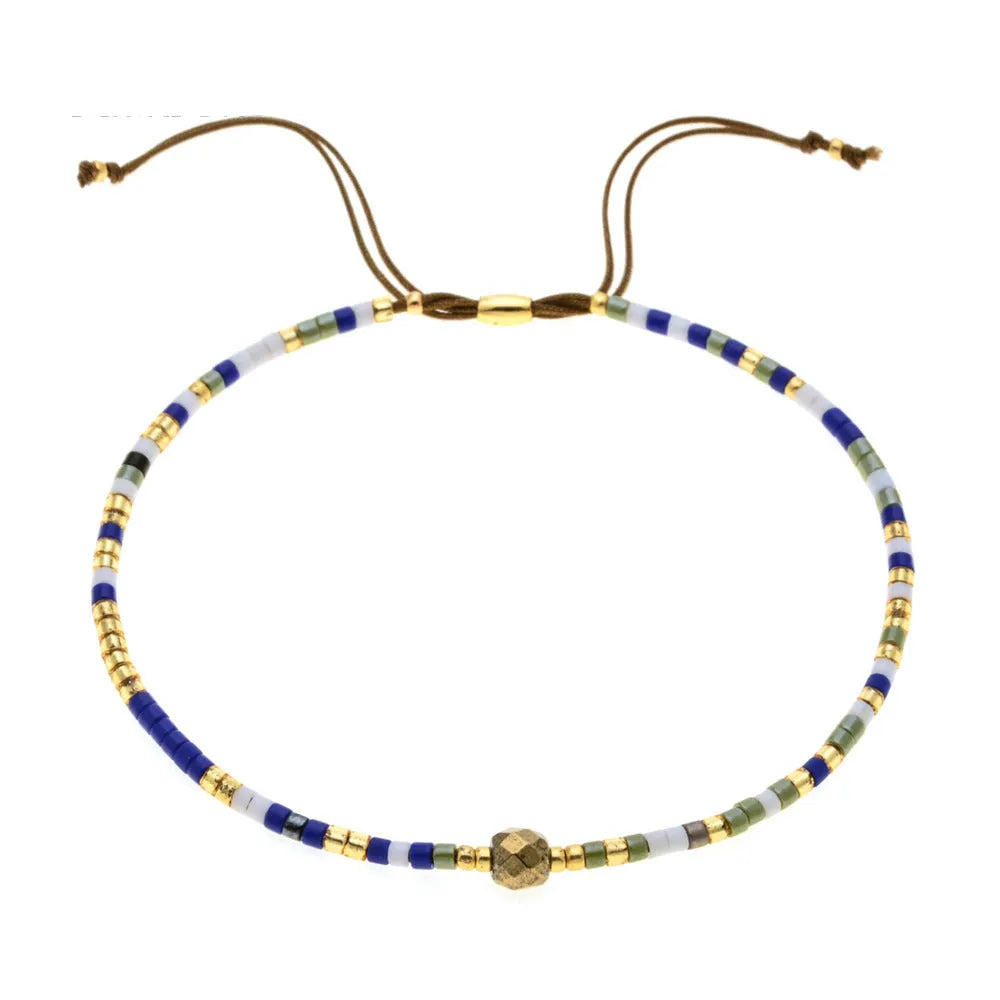 Close-up of a handmade Bohemian women's bracelet with colourful semi-precious stone and glass beads on a geometric string.