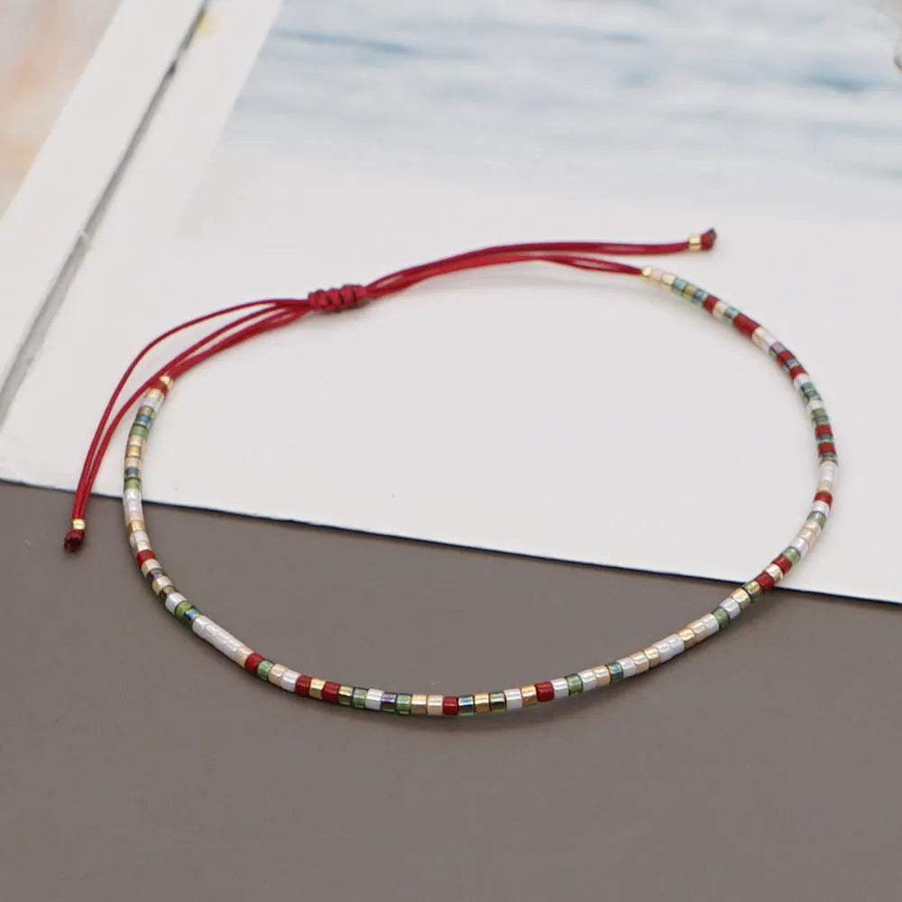 Close-up of a handmade Bohemian women's bracelet with colourful semi-precious stone and glass beads on a geometric string.