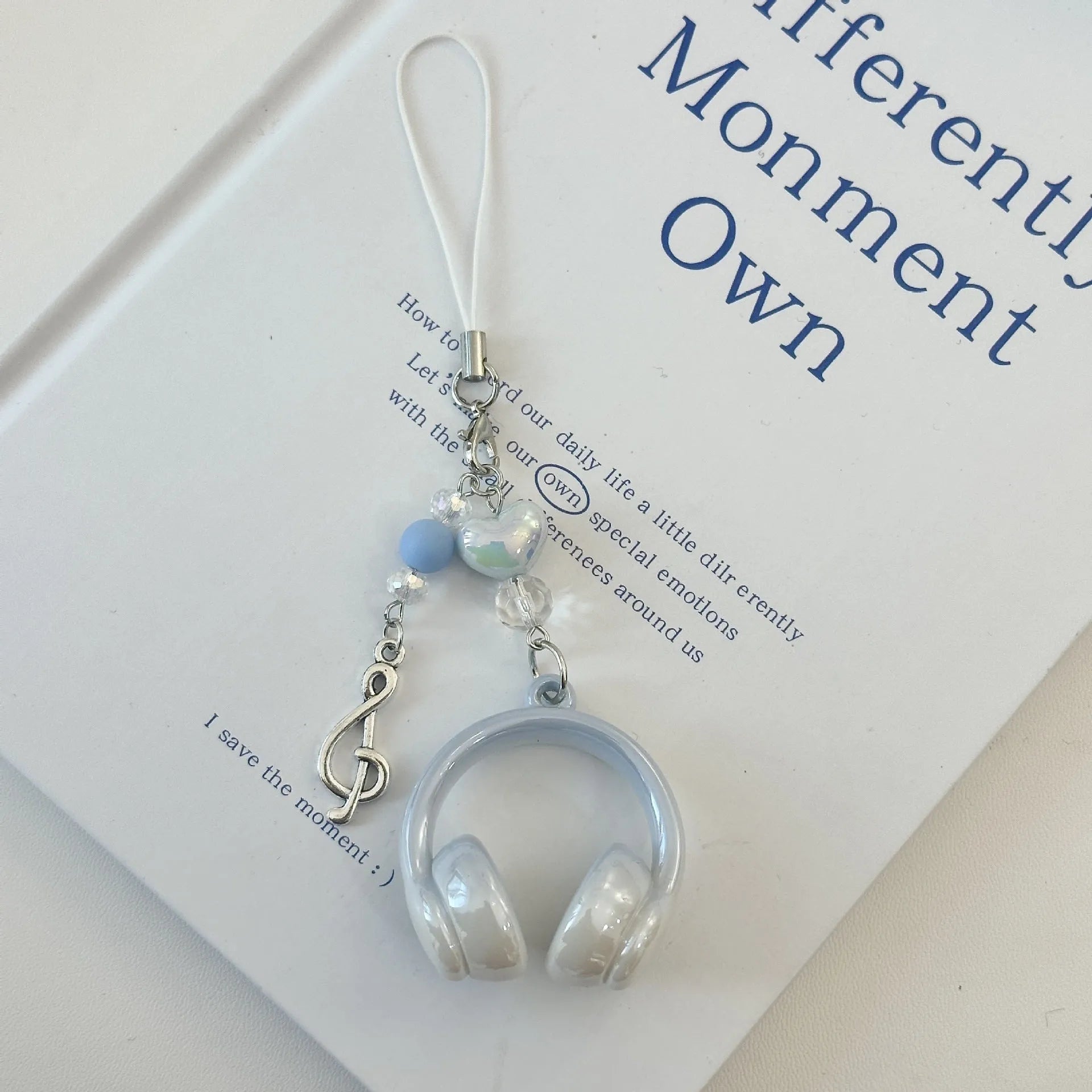 Creative music headset keychain with gradient blue resin earphone pendant and alloy keyring on a plain background