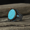 Men's turquoise alloy ring with antique silver finish showing round band design