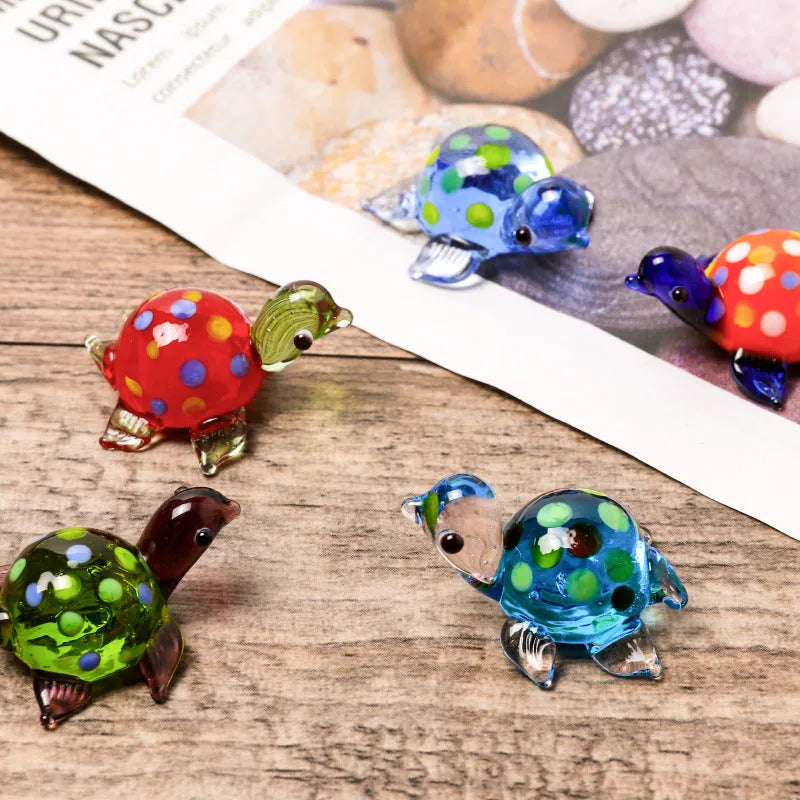 Geometric glass turtle ornament with blue head and blue shell on wooden surface