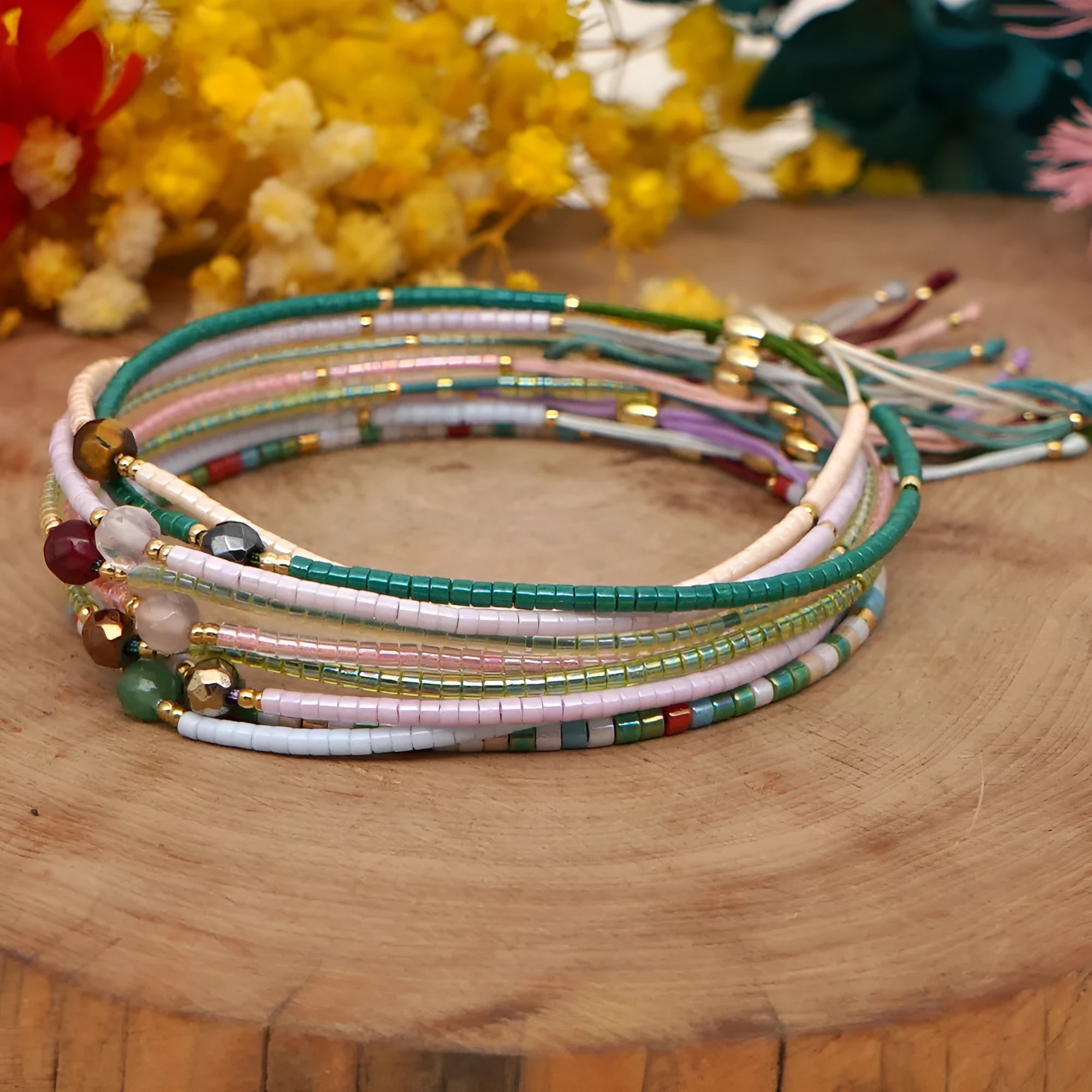 Close-up of a handmade Bohemian women's bracelet with colourful semi-precious stone and glass beads on a geometric string.