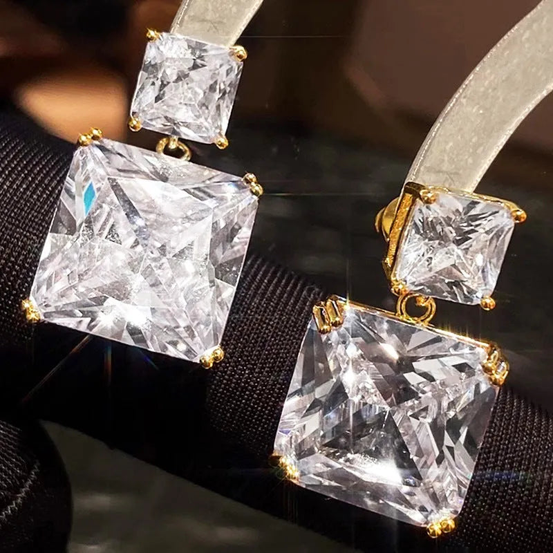 A pair of geometric square-shaped copper earrings for women, shown in white gold and gold colour options.