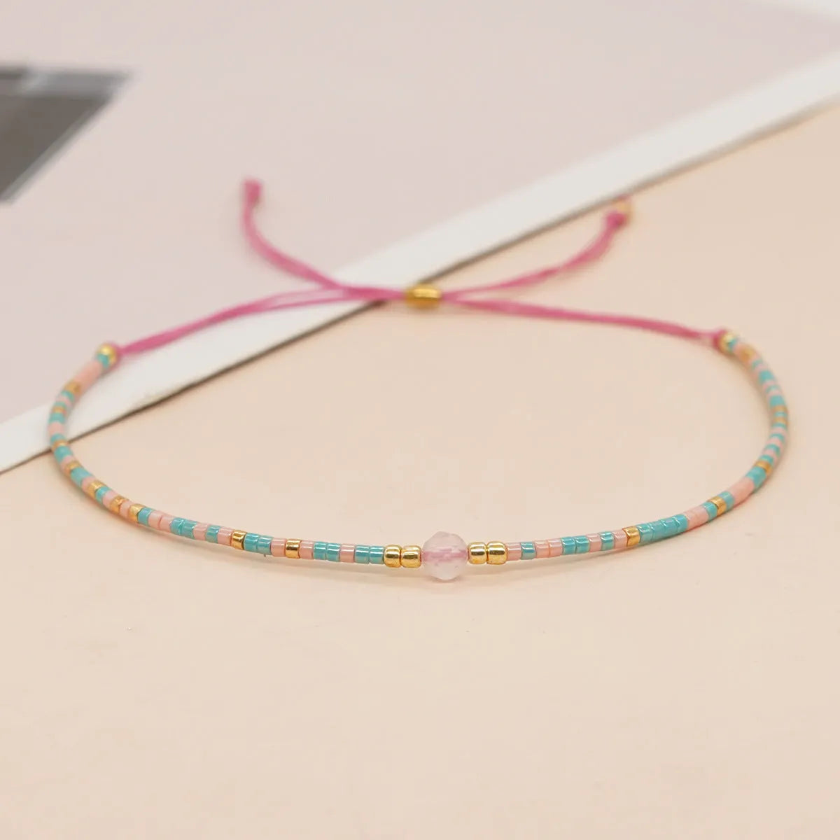Close-up of a handmade Bohemian women's bracelet with colourful semi-precious stone and glass beads on a geometric string.