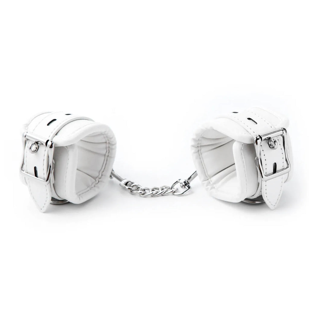White PU sponge bondage set showing handcuffs, foot cuffs, and neck scarf arranged together