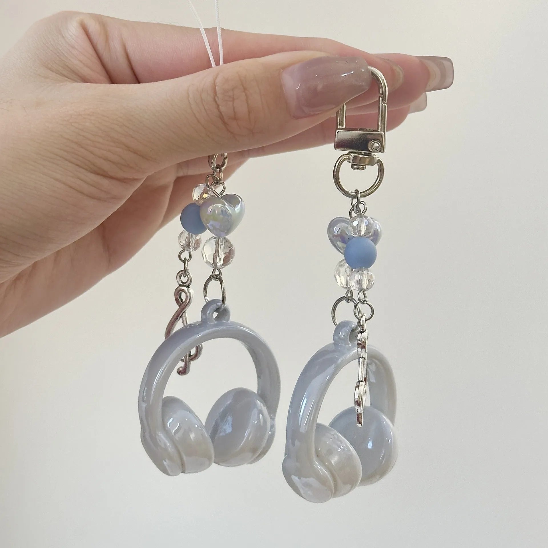 Creative music headset keychain with gradient blue resin earphone pendant and alloy keyring on a plain background