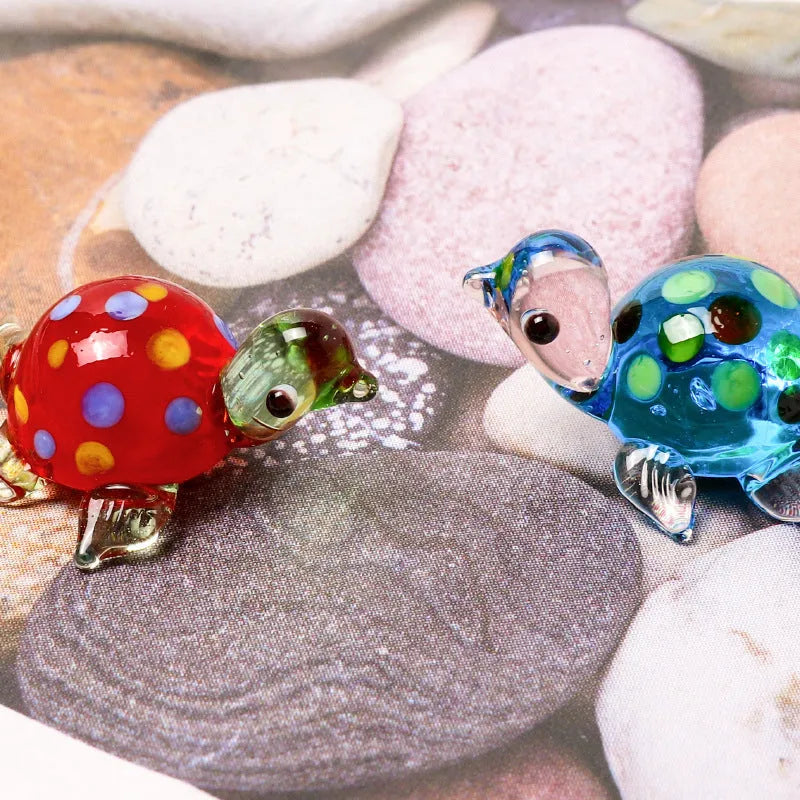Geometric glass turtle ornament with blue head and blue shell on wooden surface