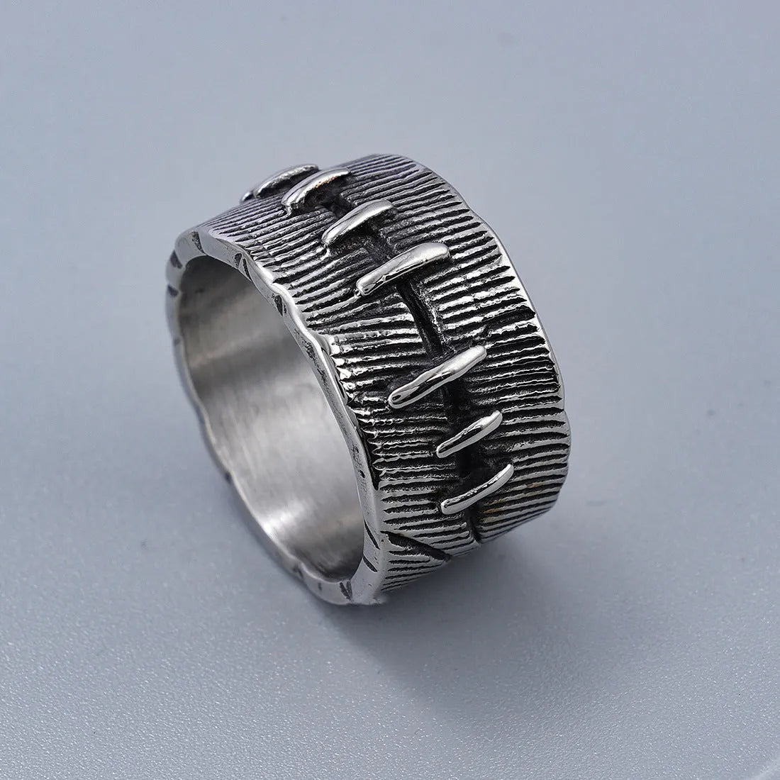Geometric titanium steel double ring in a dark punk style with a U-shape and stitched design.