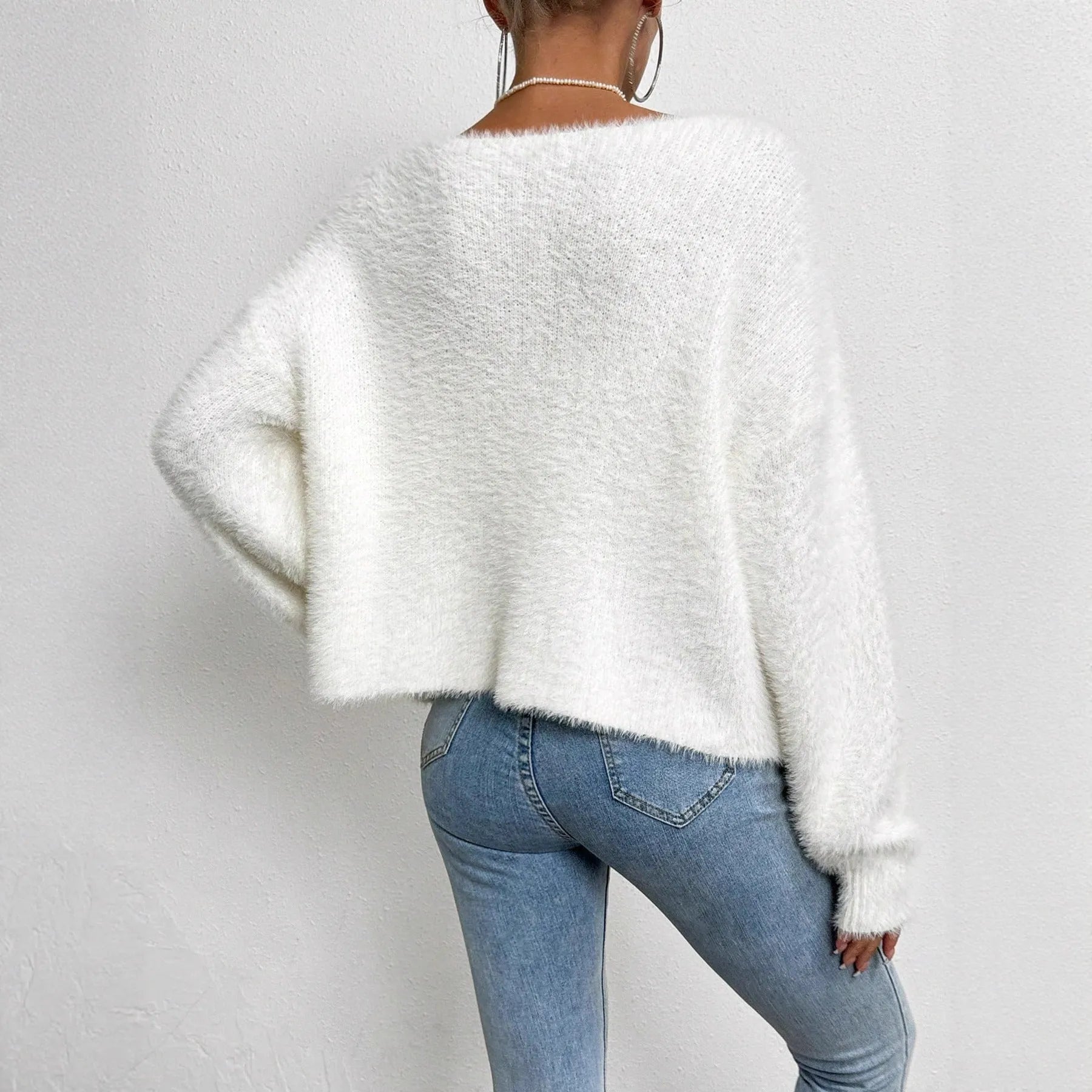 Women's solid white V-neck cardigan with beaded knit detail, shown on a hanger.
