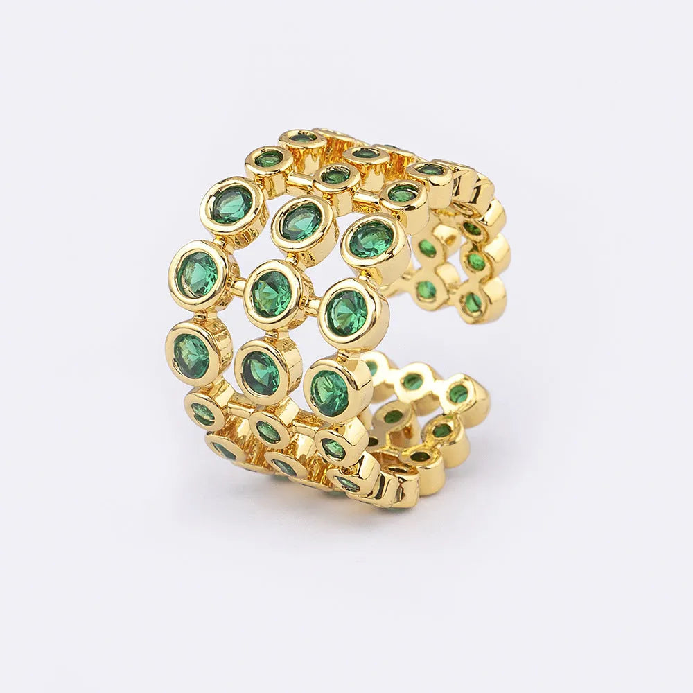 Wide band ring with gold plating and exaggerated green zircon detailing on copper base