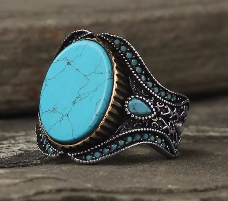 Men's turquoise alloy ring with antique silver finish showing round band design