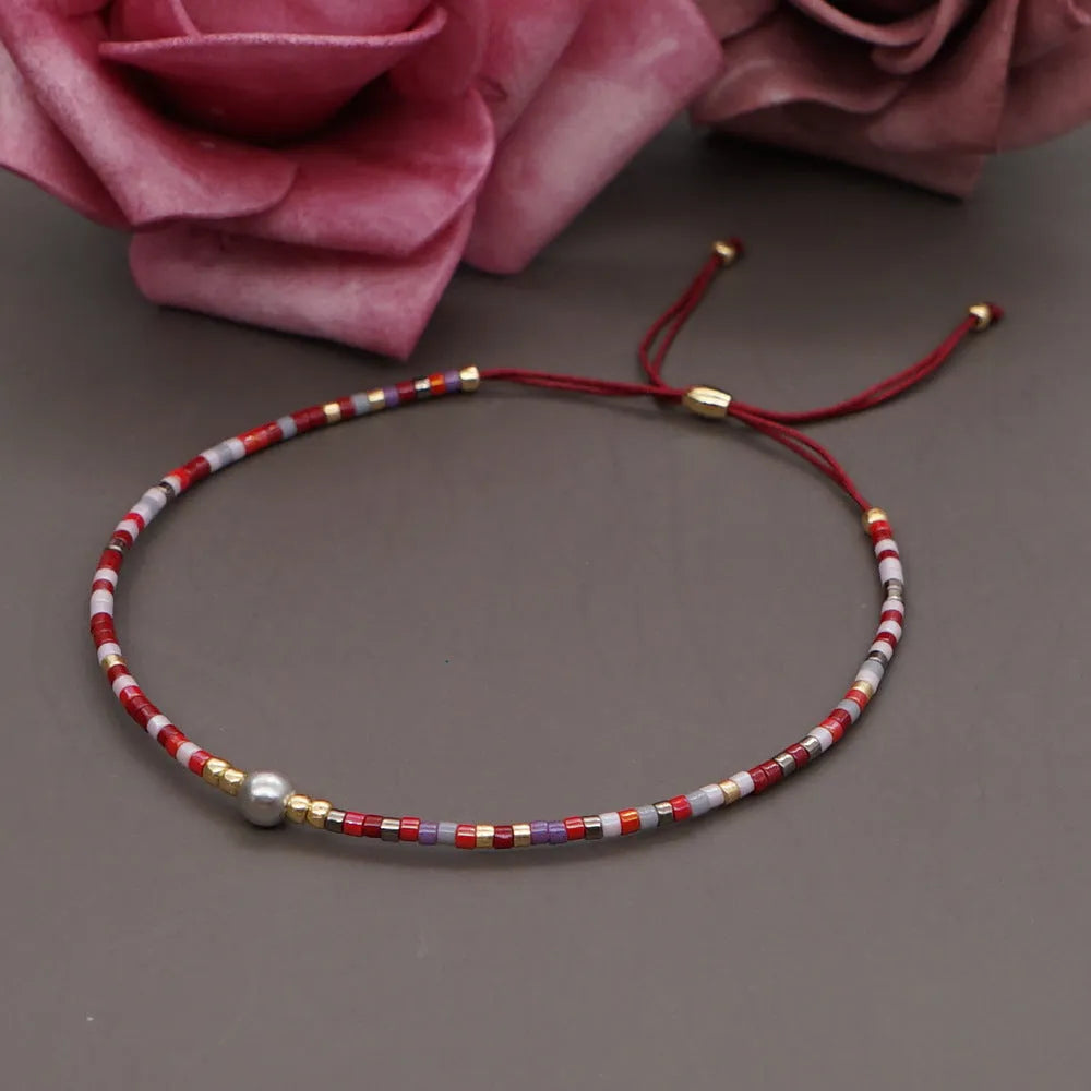 Close-up of a handmade Bohemian women's bracelet with colourful semi-precious stone and glass beads on a geometric string.