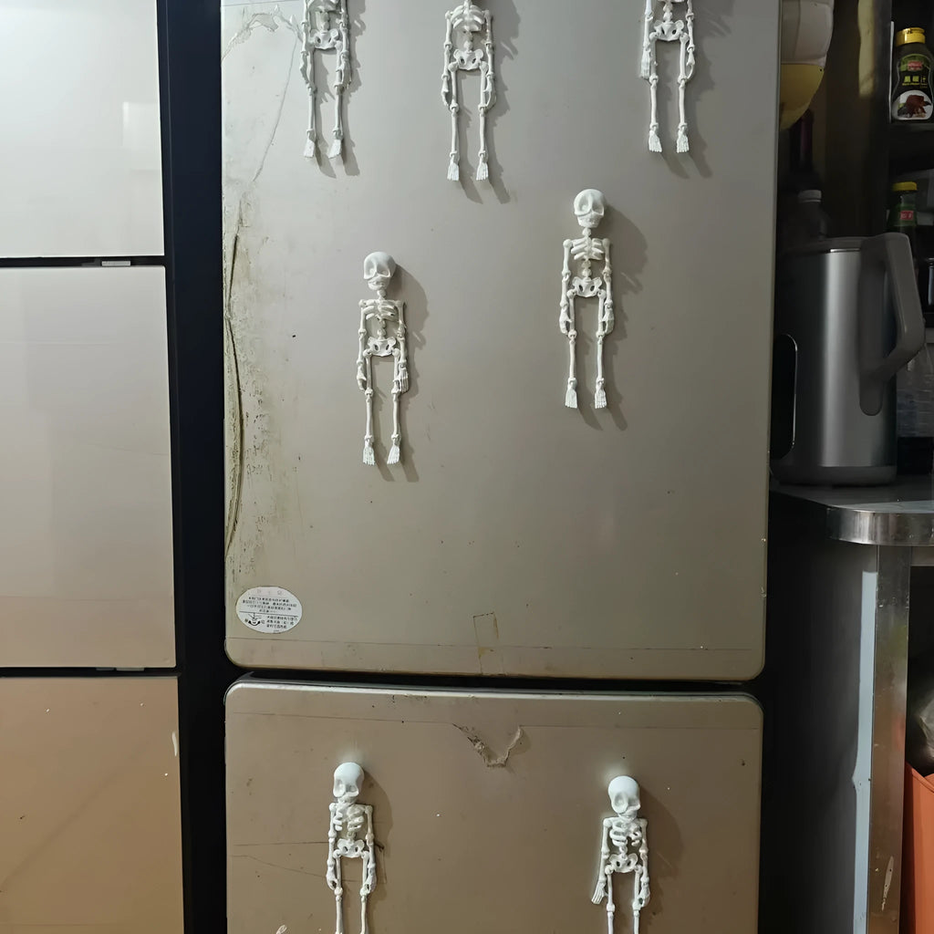 3D-printed white skull Halloween fridge magnet ornament on a refrigerator door.