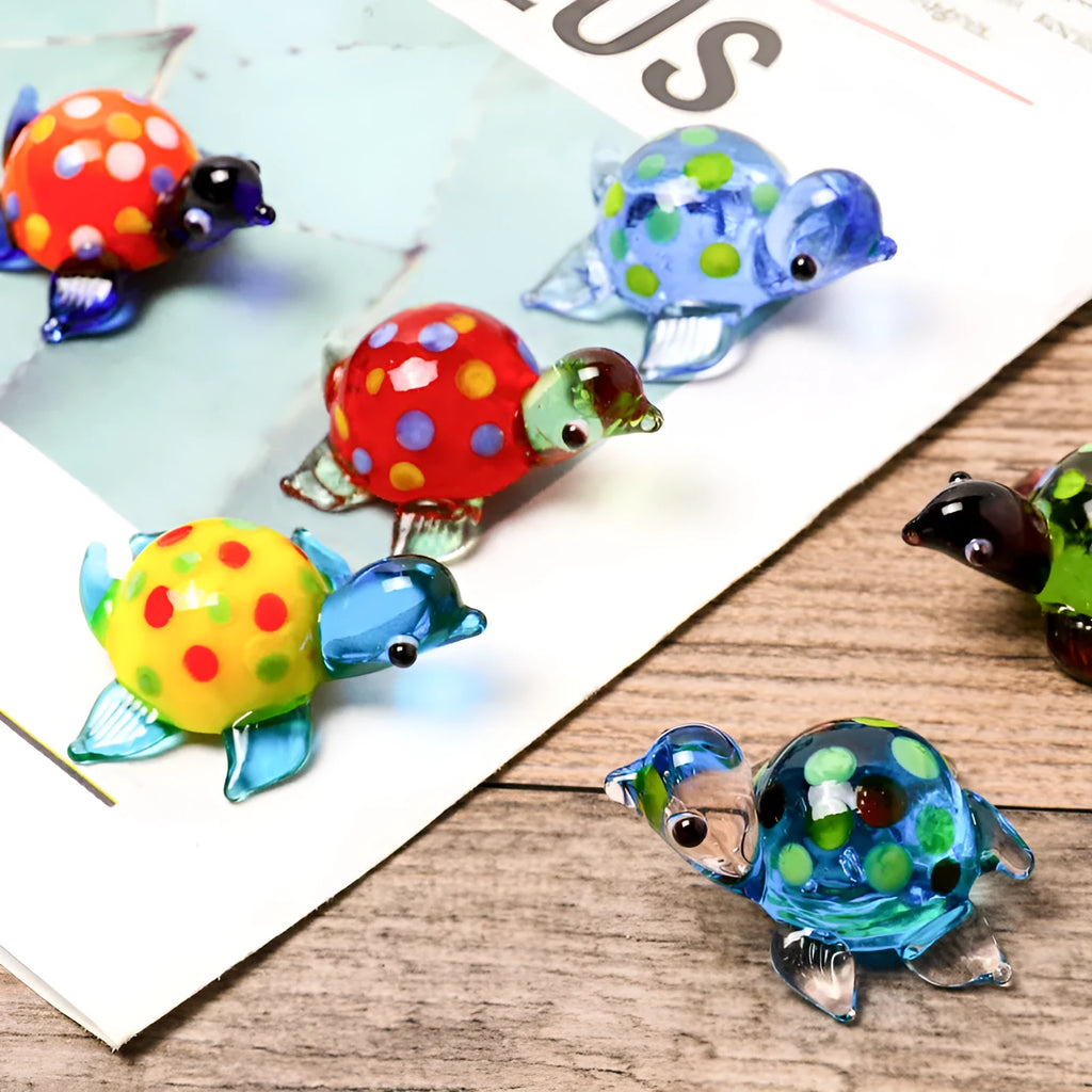 Geometric glass turtle ornament with blue head and blue shell on wooden surface