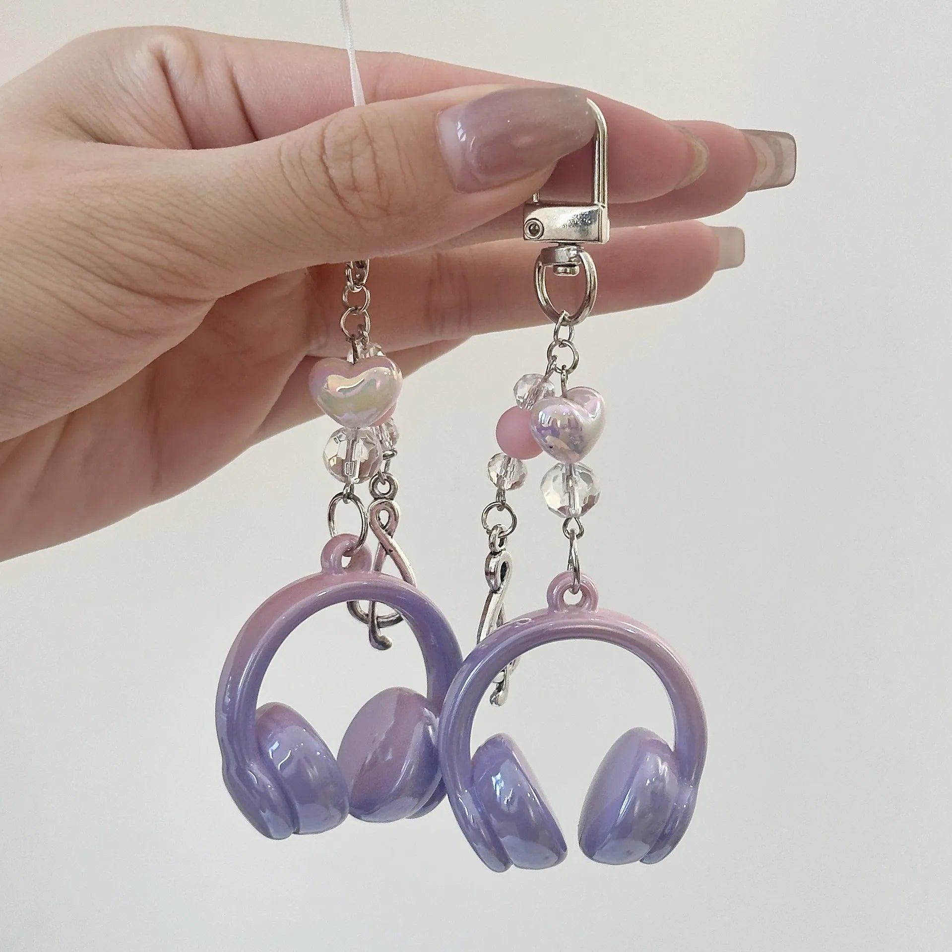 Creative music headset keychain with gradient blue resin earphone pendant and alloy keyring on a plain background