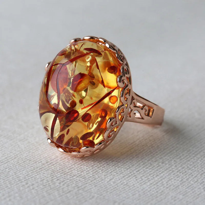 Close-up of an amber ethnic-style beeswax ring with a warm-toned stone and alloy band.