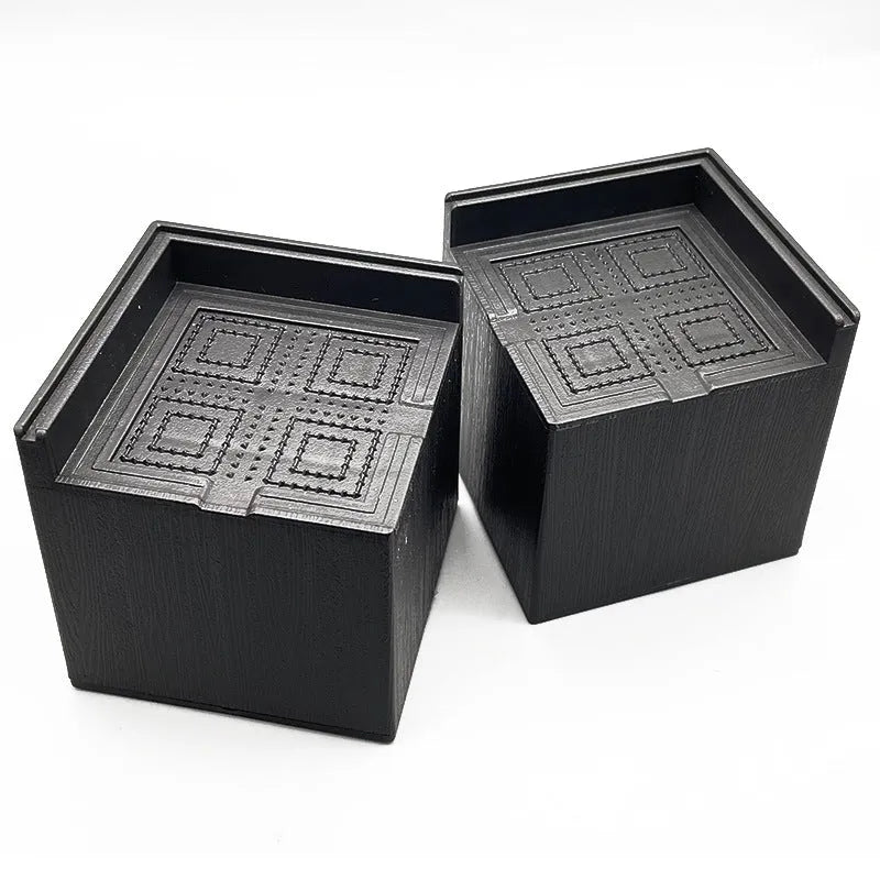 Four black plastic furniture height adjustment mats for sofa or bed feet.