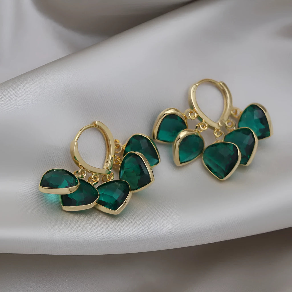 Green glass heart-shaped pendant on copper ear clip earrings with alloy inlay detail.