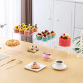 White plastic stackable dessert display stand with six pieces arranged in tiered formation