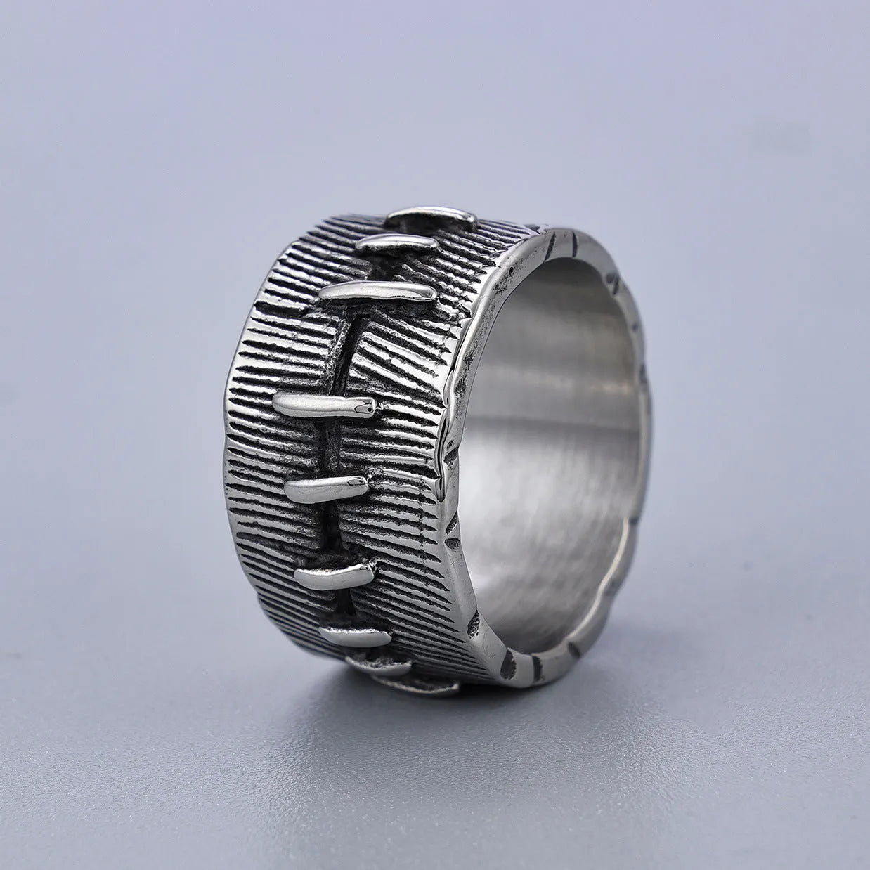 Geometric titanium steel double ring in a dark punk style with a U-shape and stitched design.