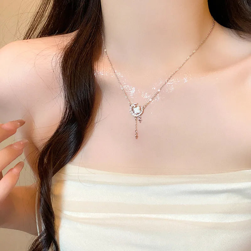 Women's gold star and moon zirconium necklace on an adjustable chain.