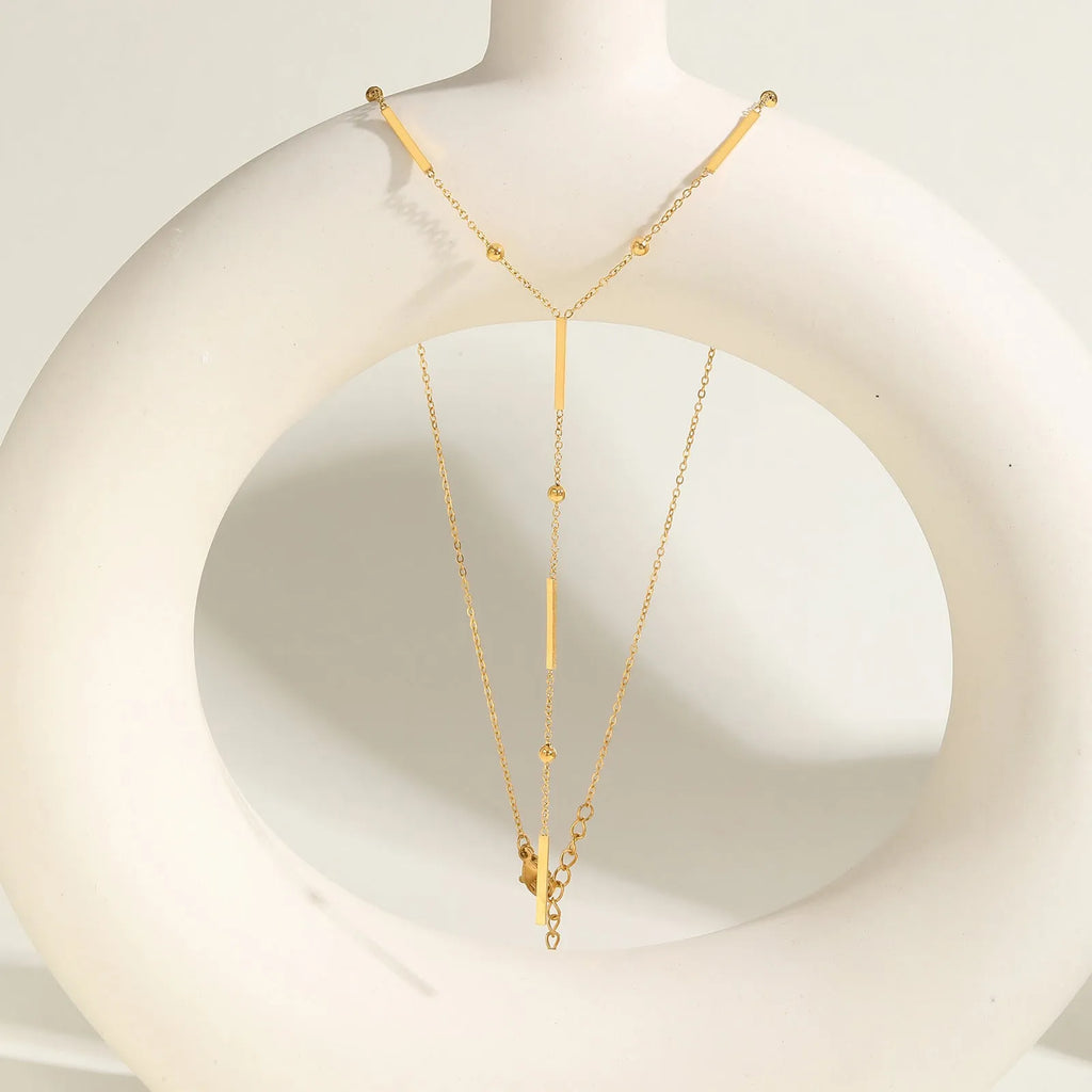 Women's stainless steel gold electroplated geometric pendant necklace on display