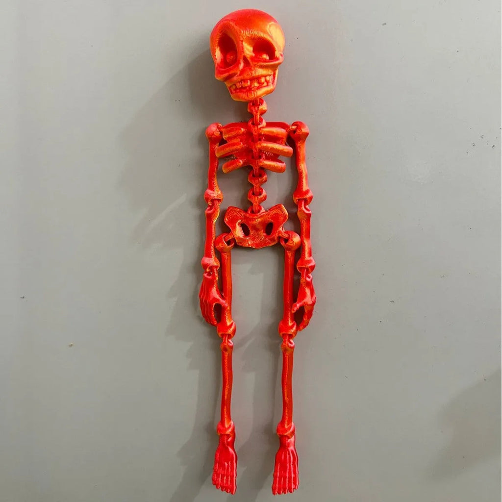3D-printed white skull Halloween fridge magnet ornament on a refrigerator door.