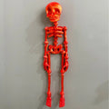 3D-printed white skull Halloween fridge magnet ornament on a refrigerator door.