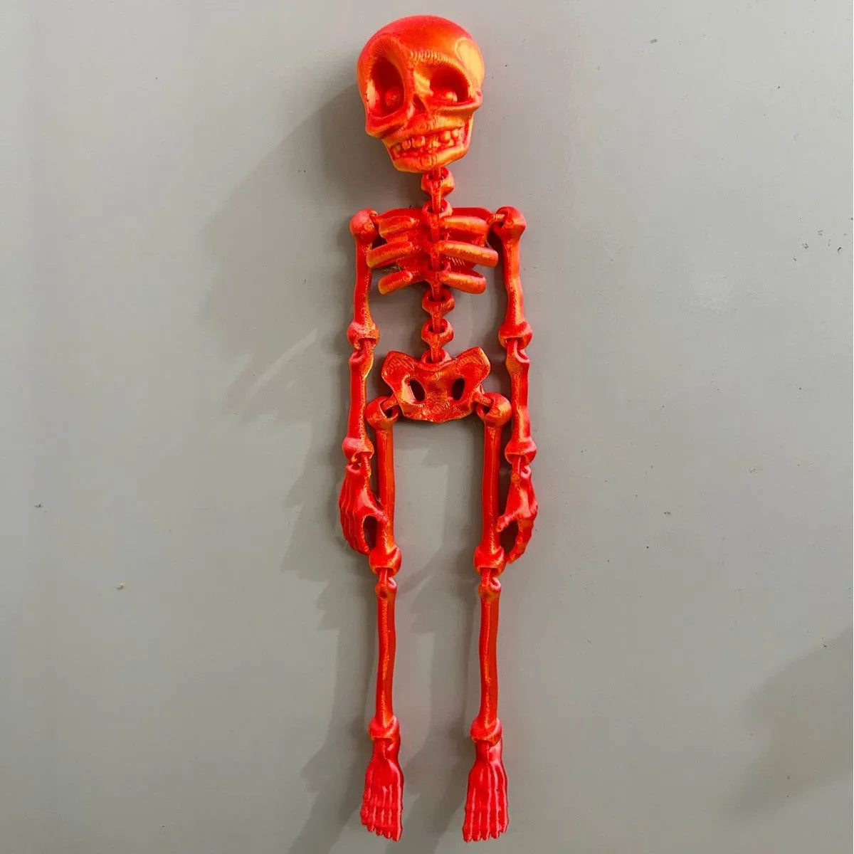 3D-printed white skull Halloween fridge magnet ornament on a refrigerator door.