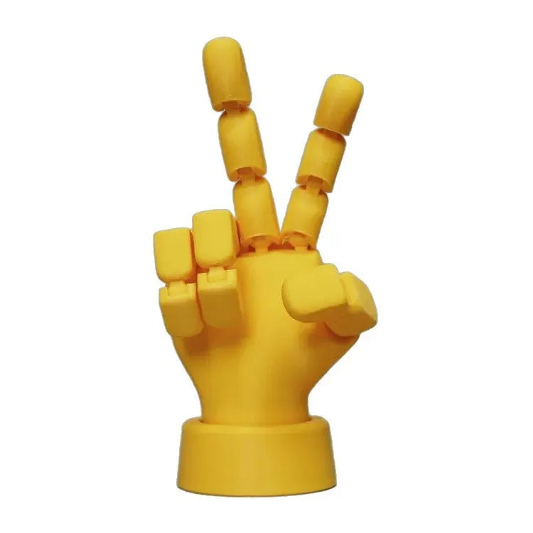 Yellow articulated hand prop with movable joints on a white background.
