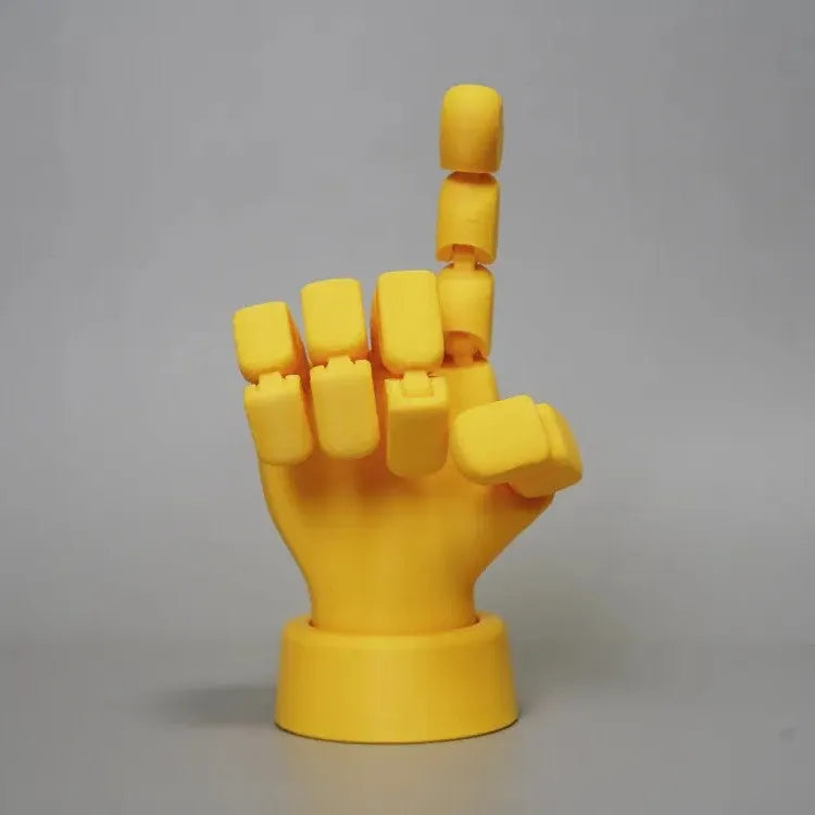 Yellow articulated hand prop with movable joints on a white background.