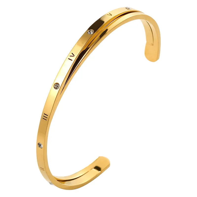 Open-ended stainless steel bracelet with zircon stones in gold, rose, or silver colour on a wrist.