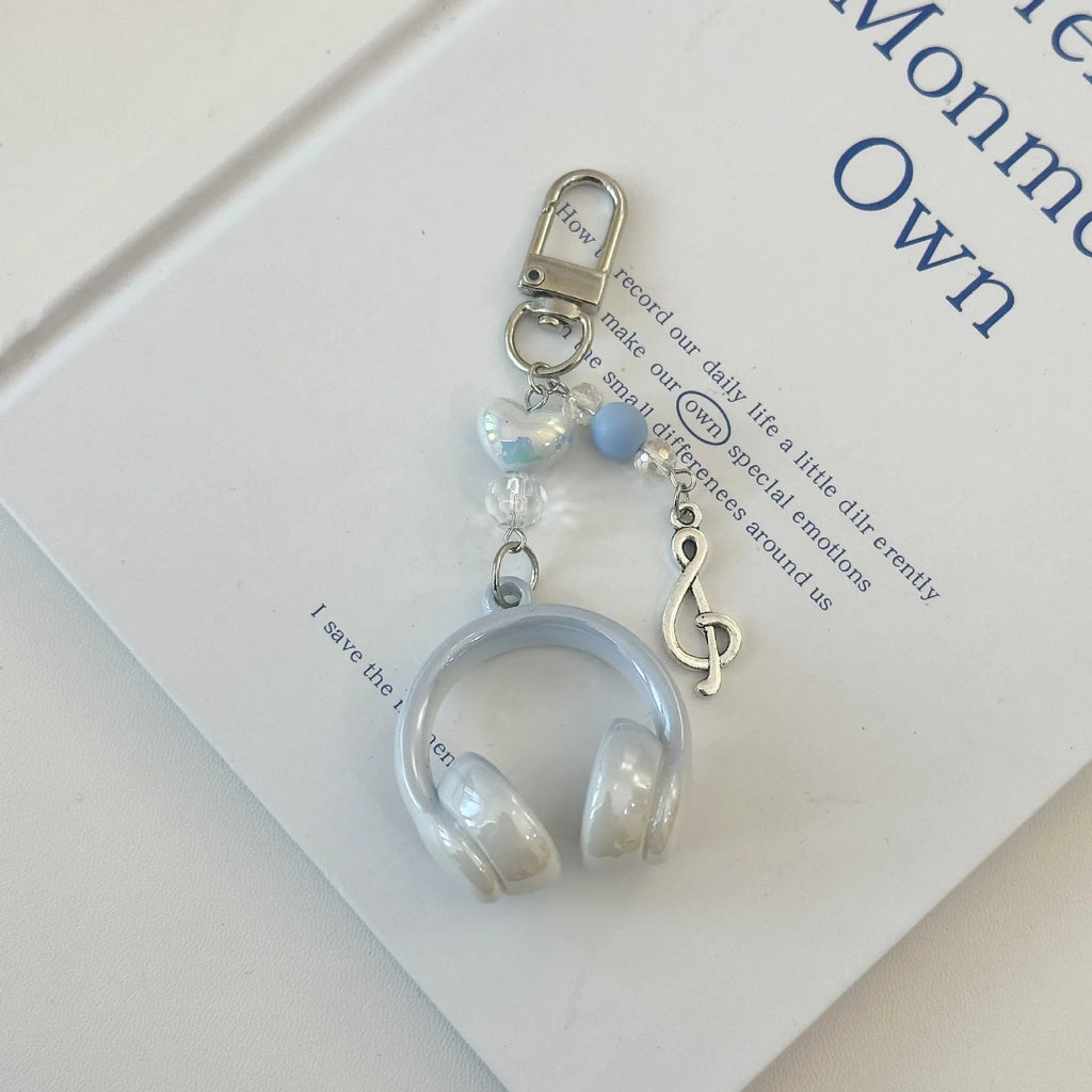 Creative music headset keychain with gradient blue resin earphone pendant and alloy keyring on a plain background