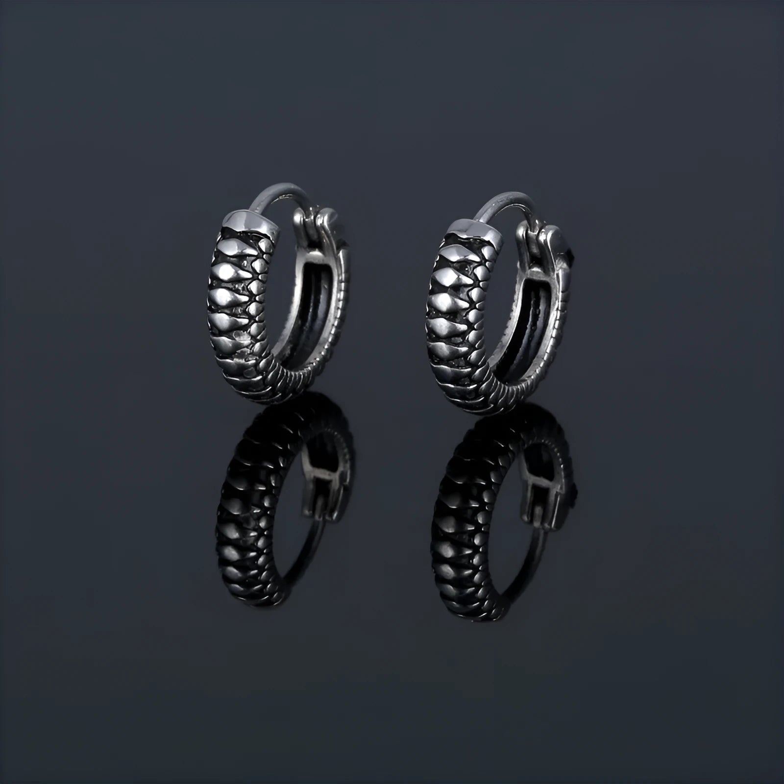 Silver geometric circular earrings made from twisted stainless steel stripes on a white background.