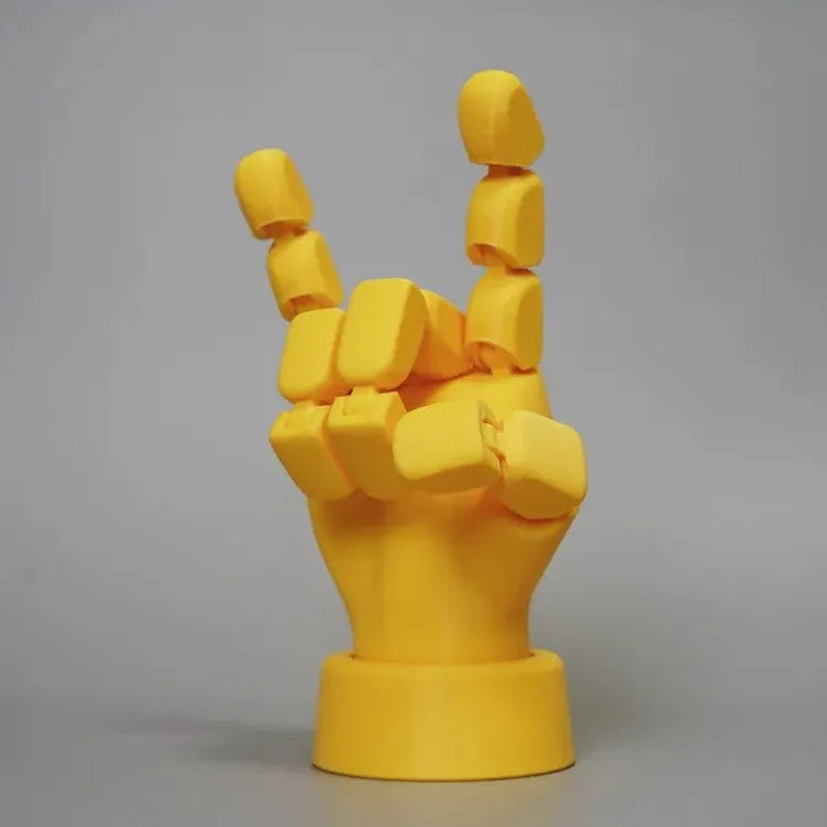 Yellow articulated hand prop with movable joints on a white background.