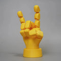 Yellow articulated hand prop with movable joints on a white background.