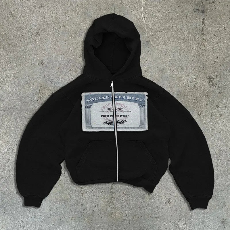 A person wearing a black unisex loose-fit hooded zip-up jacket with a letter pattern and zippered pockets.