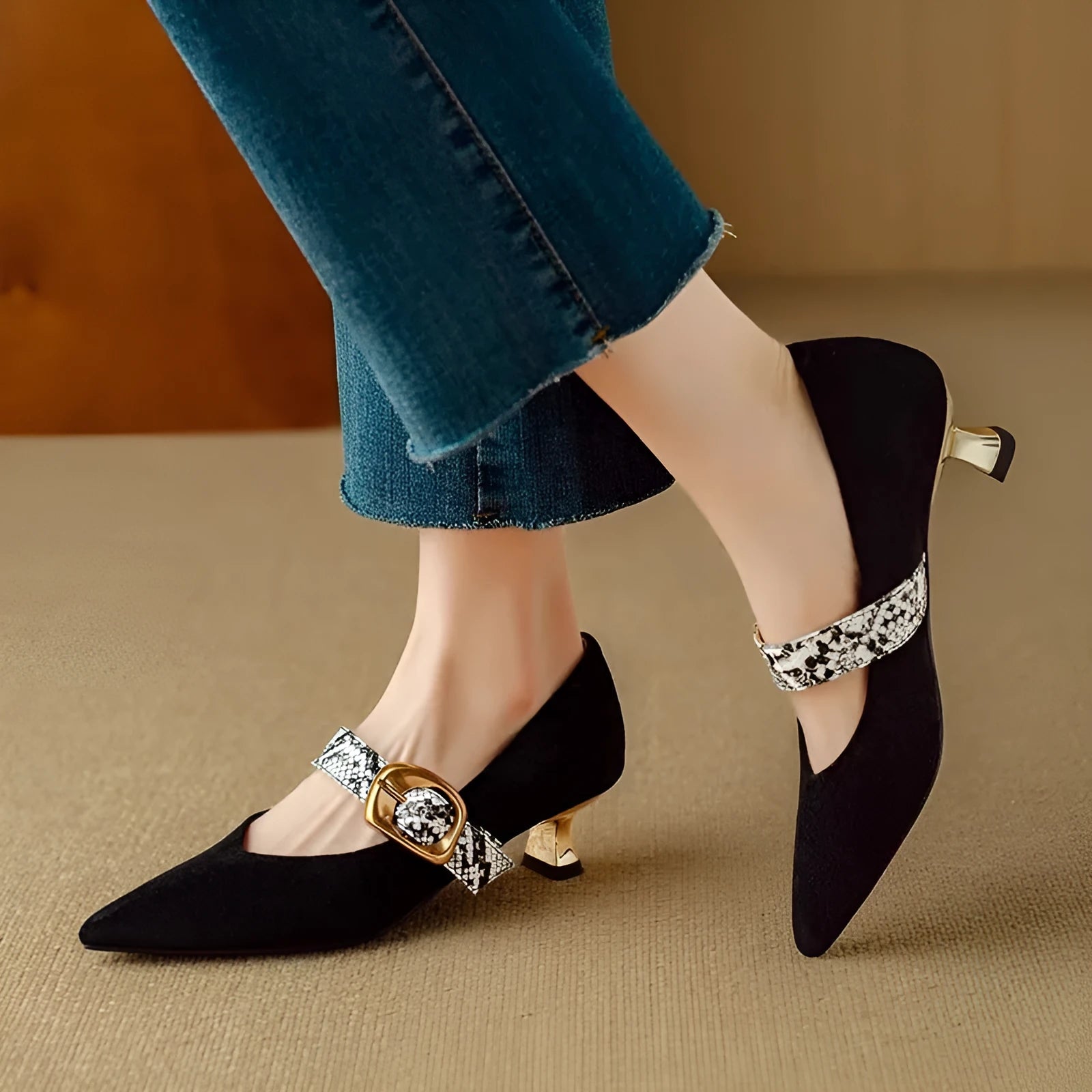 Black pointed-toe stiletto heels with a buckle fastening on the low-cut upper