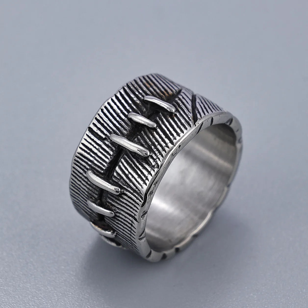Geometric titanium steel double ring in a dark punk style with a U-shape and stitched design.