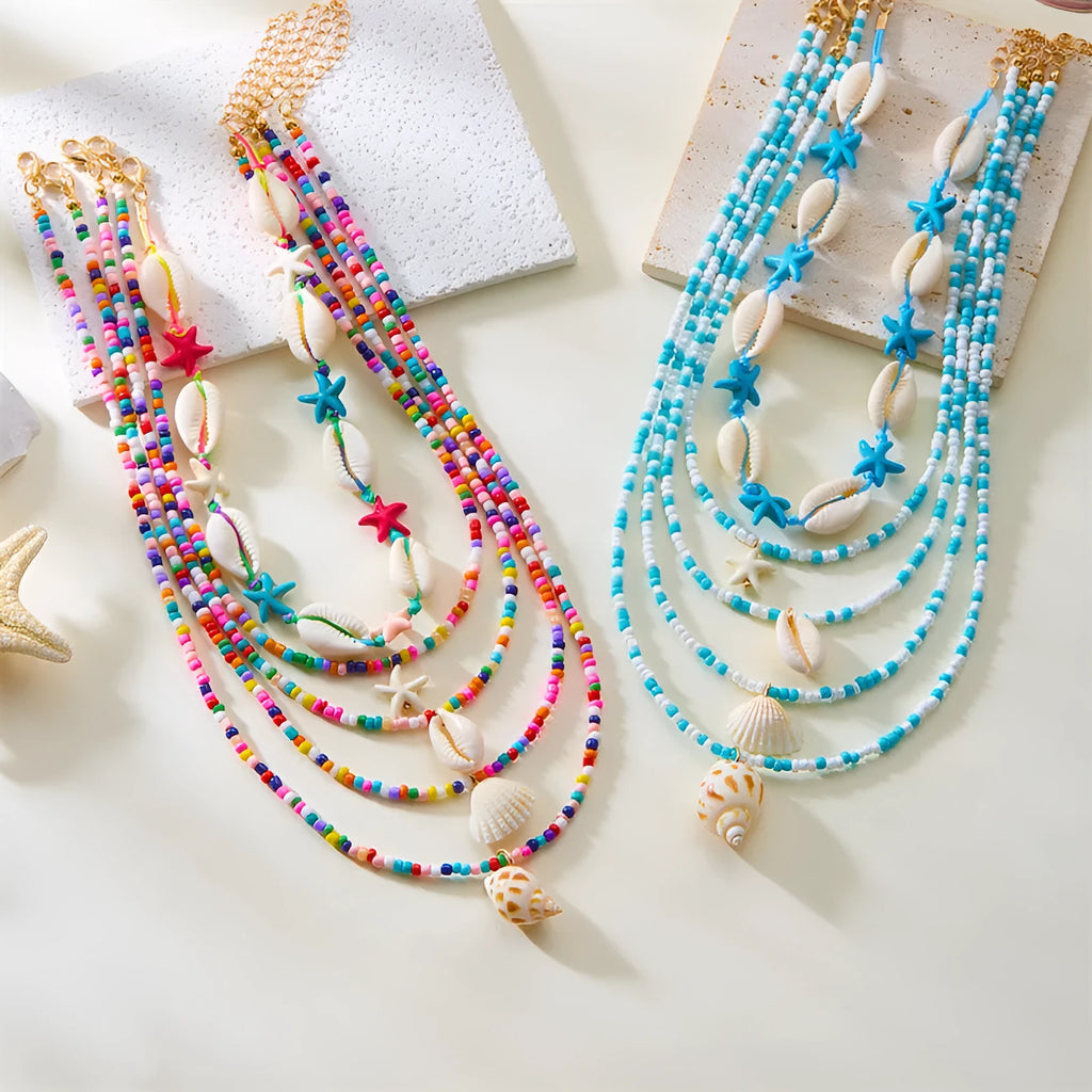 Blue multi-layer women's necklace set with starfish, shell, and conch bead pendants on bead chains
