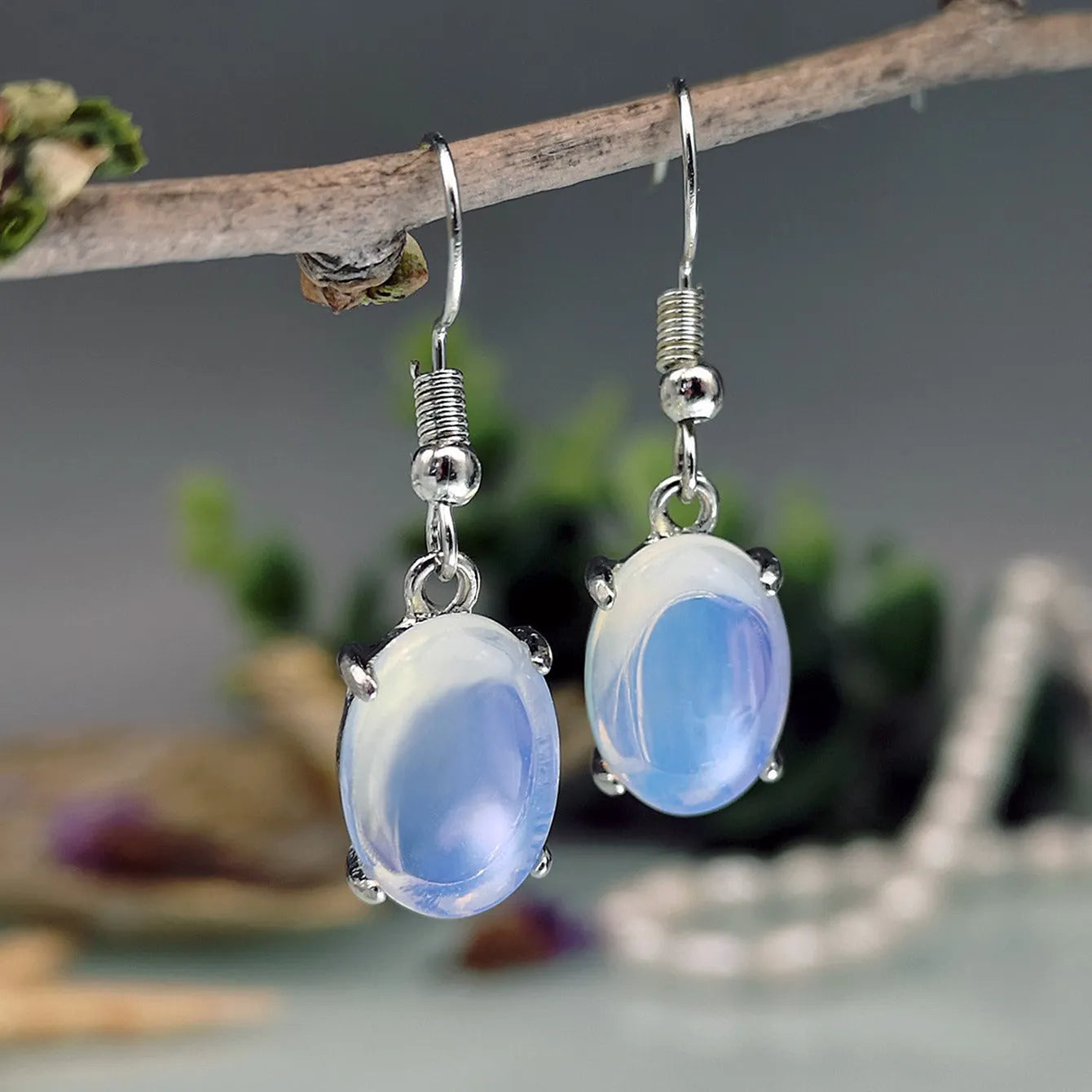 Pair of white retro-style drop earrings with a cross design and opal-like finish.